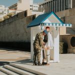 Greek Presidential Guard soldier in traditional uniform at Athens monument.